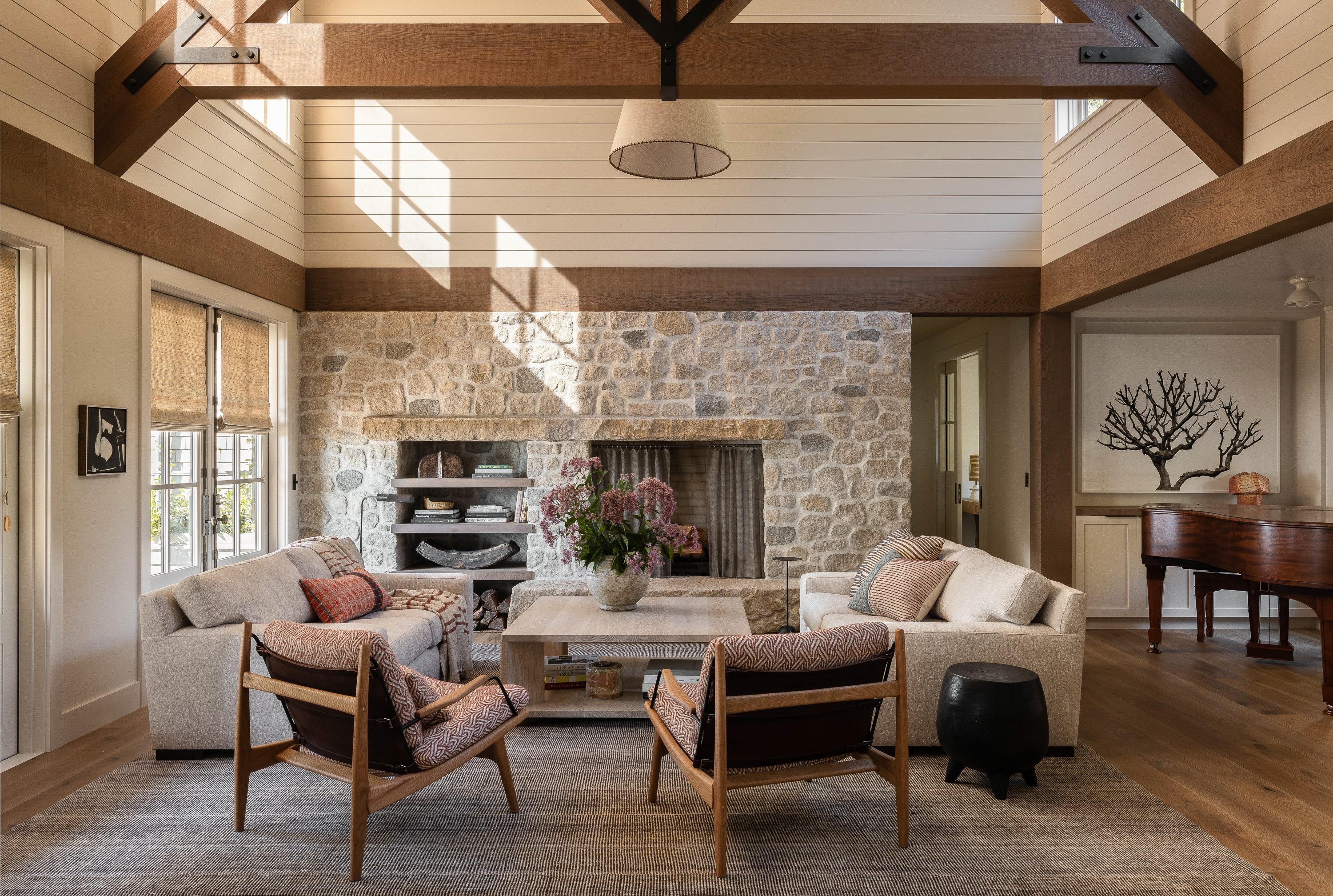 The living room showcases an open design concept, accentuated by large timber trusses that add a sense of grandeur and rustic charm to the space.