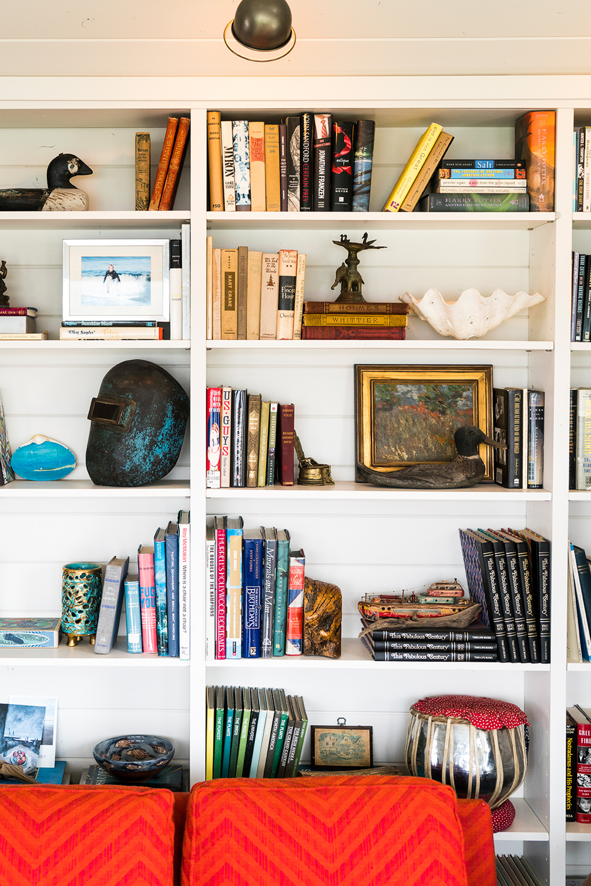 The built-in bookshelves in the living room display nautical treasures and well-loved antiques, adding to the room's eclectic charm.