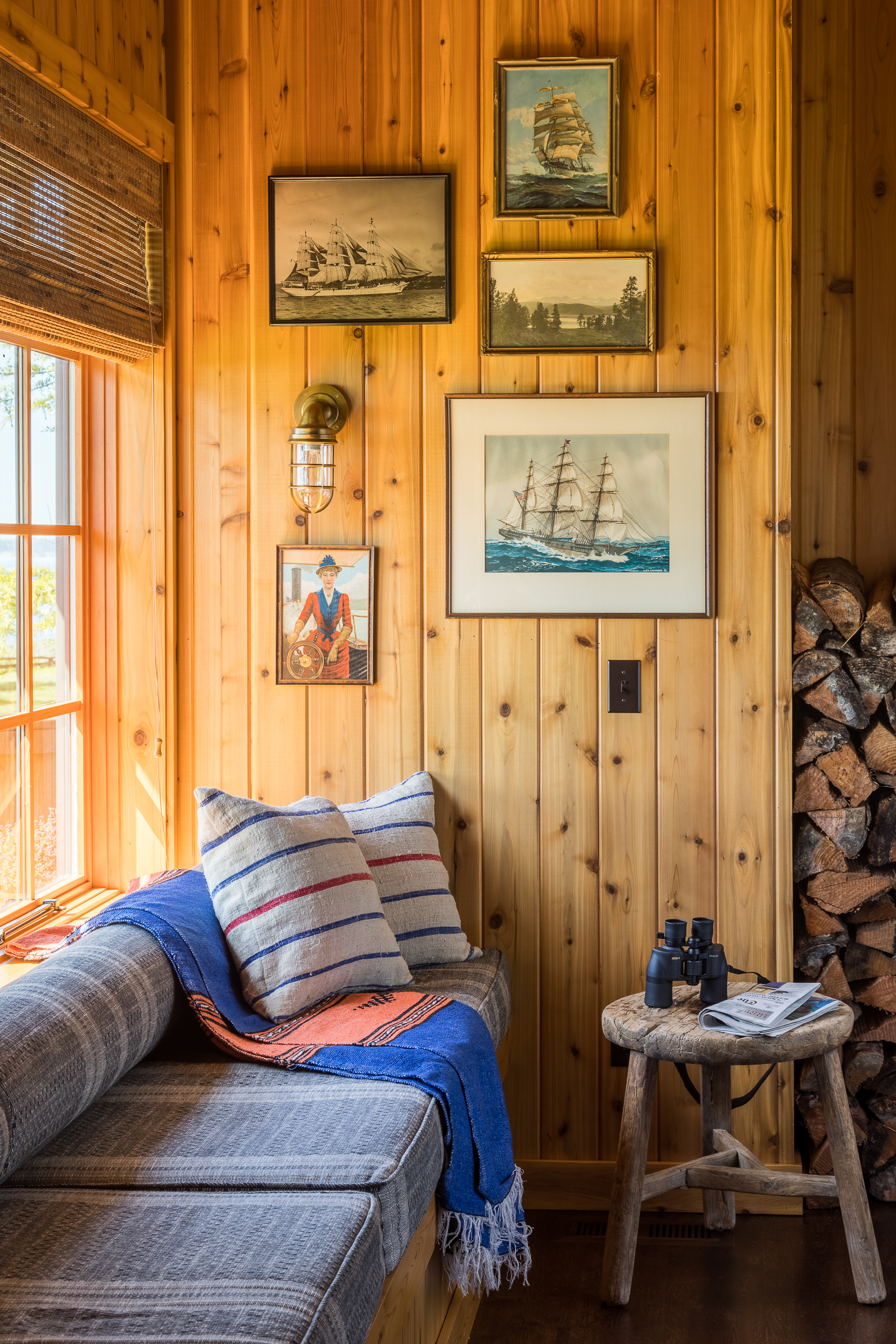 In a quiet corner of the great room, built-in bench seating invites relaxation, while a small gallery wall of nautical paintings adds a touch of maritime charm and personalization.