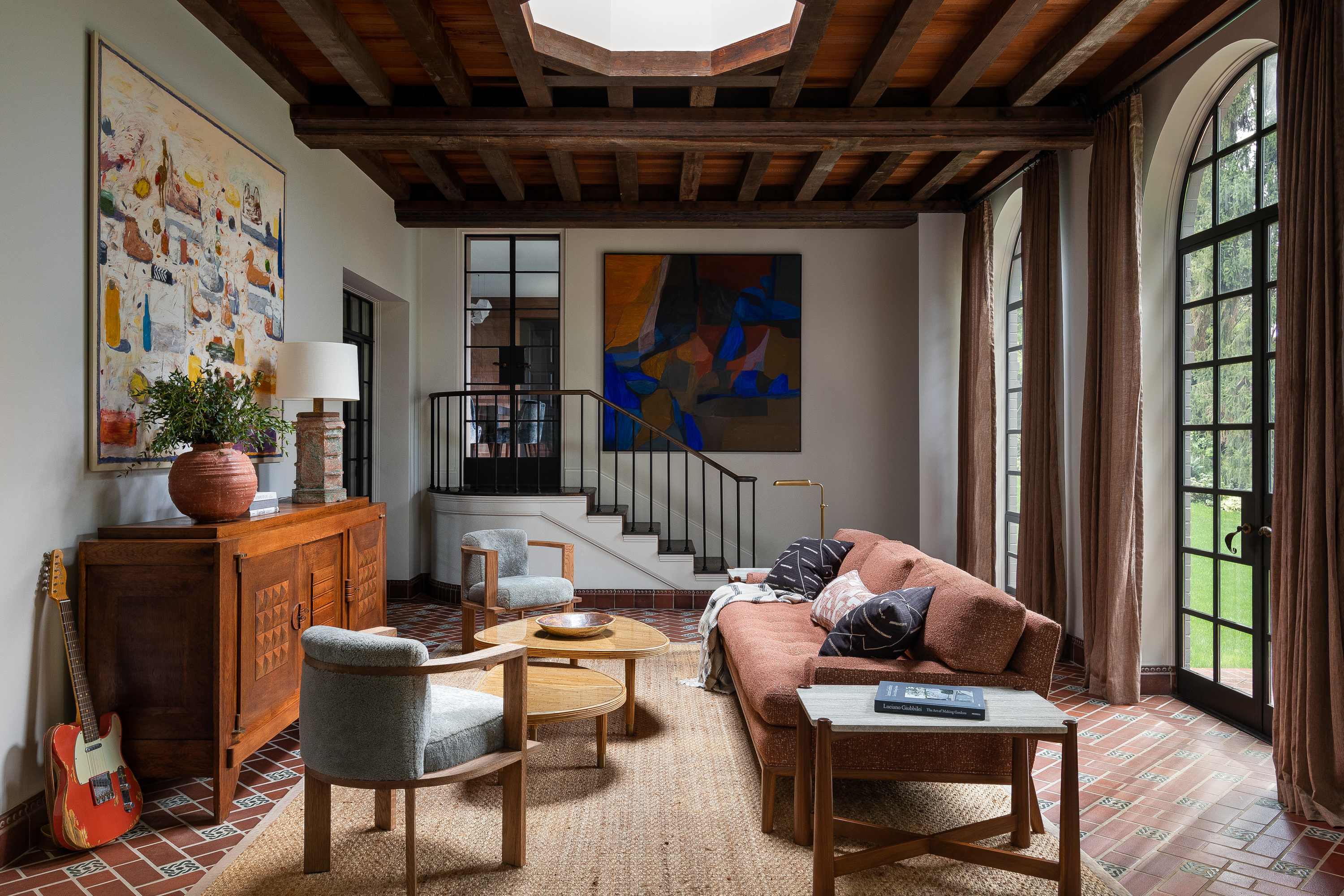 A stunning living room/atrium with vintage Charles Dudouyt pieces alongside contemporary Lawson Fenning and Jean de Merry furnishings. Featuring large-scale art by Gustavo Acosta and Margaret Tomkins.