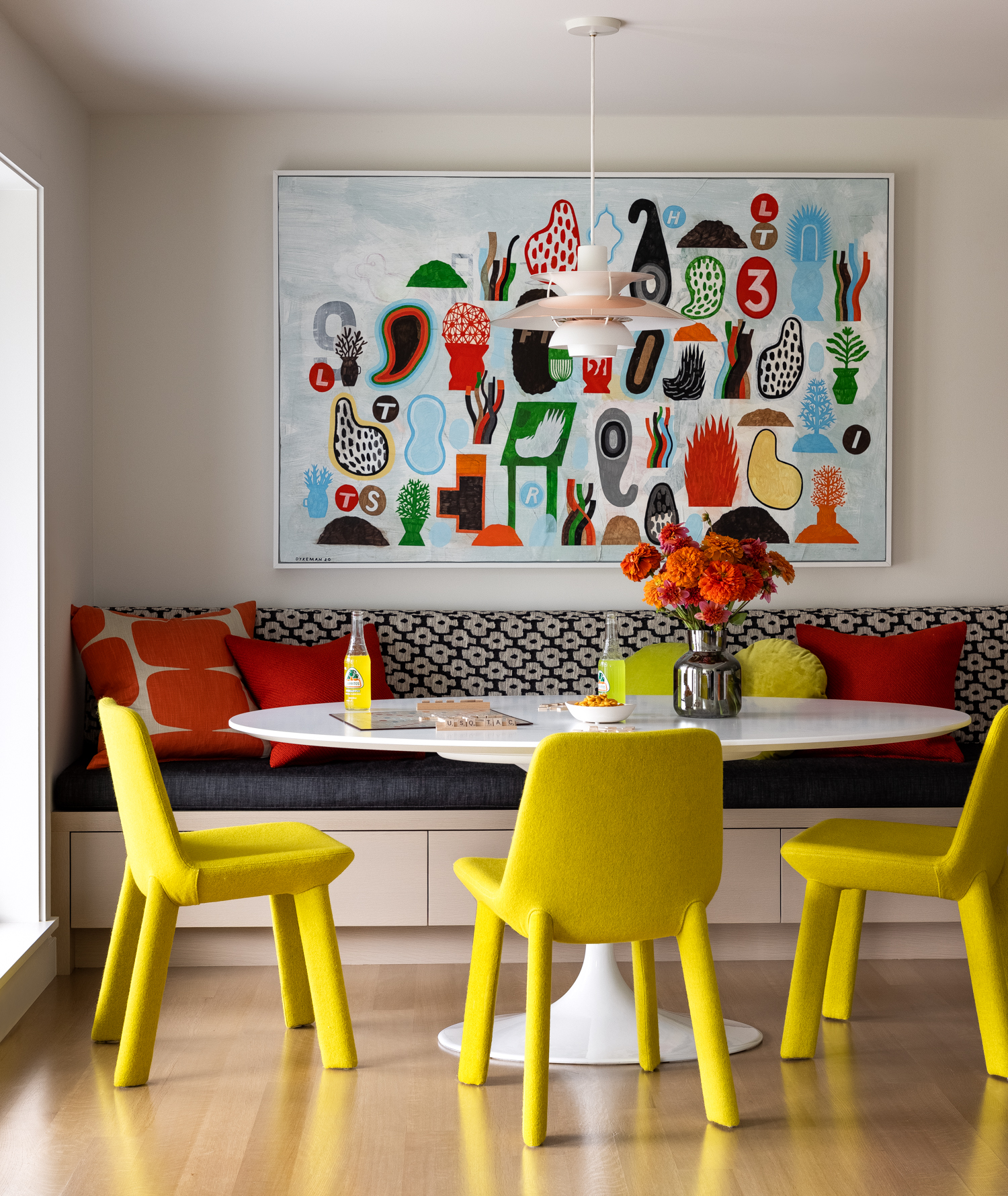 Bright yellow felt wrapped chairs paired with a mid century table and light fixture make a fun, eye-catching design.