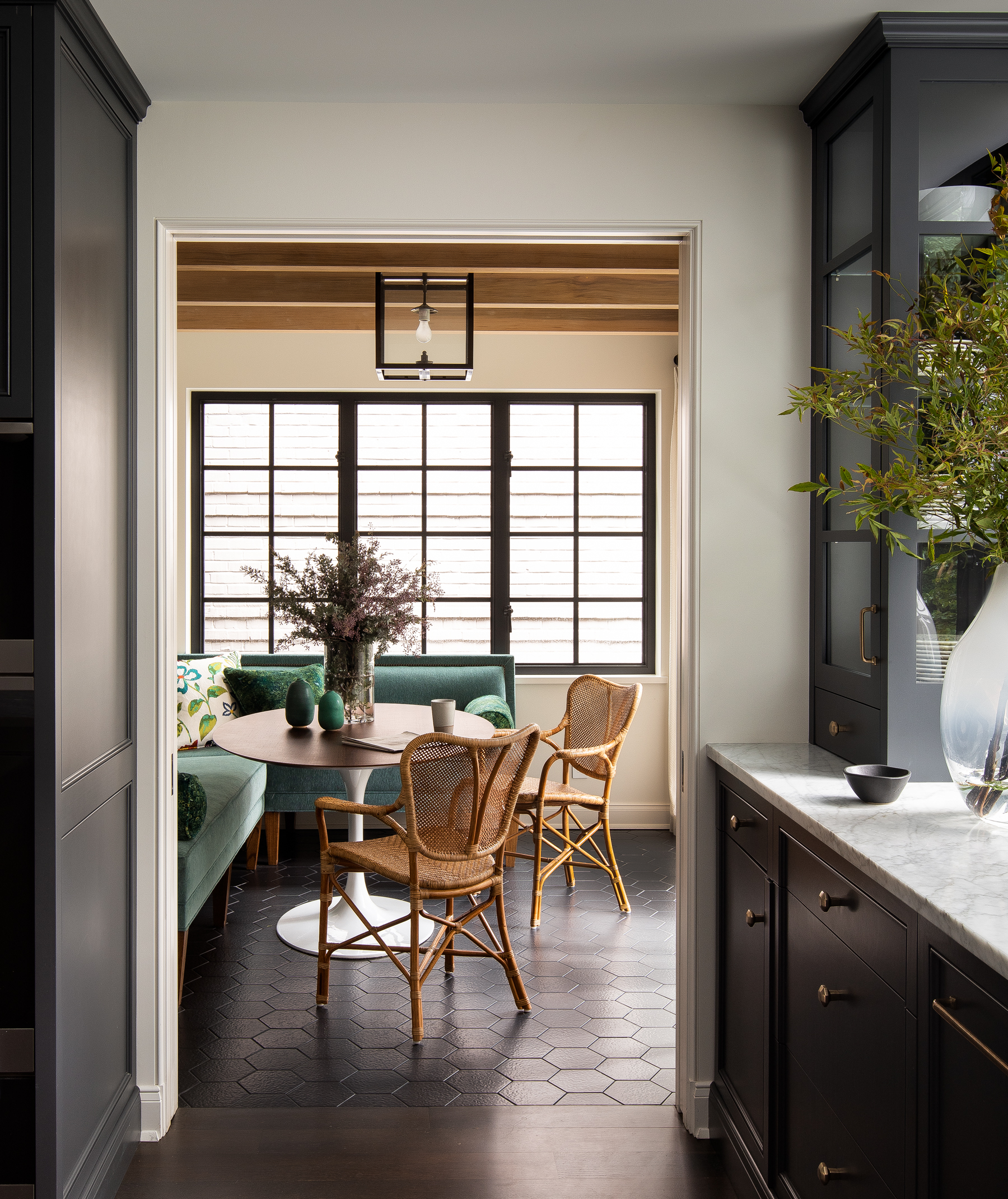 Sunroom: A bright, sunny space for breakfast with a comfortable L-shaped banquette along the wall and bamboo dining chairs for a casual dining experience.