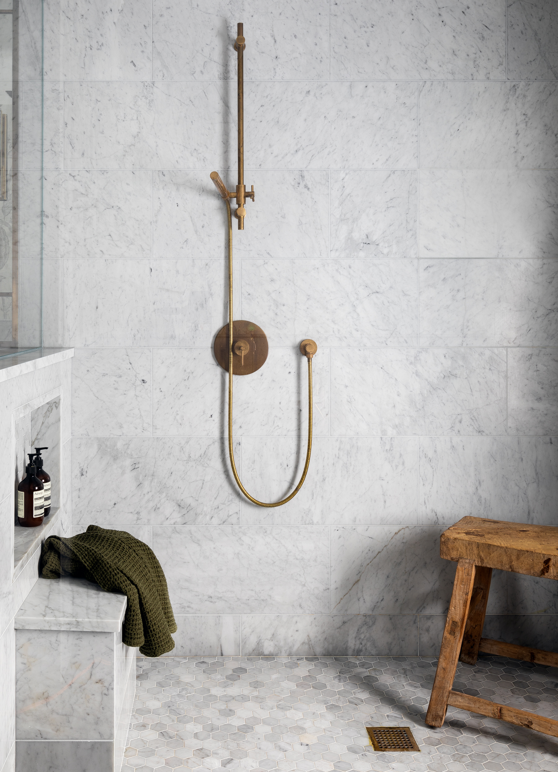 Marble and unlacquered brass in this bathroom create a classic feel. The brass will patina over time, adding to its timeless aesthetic.