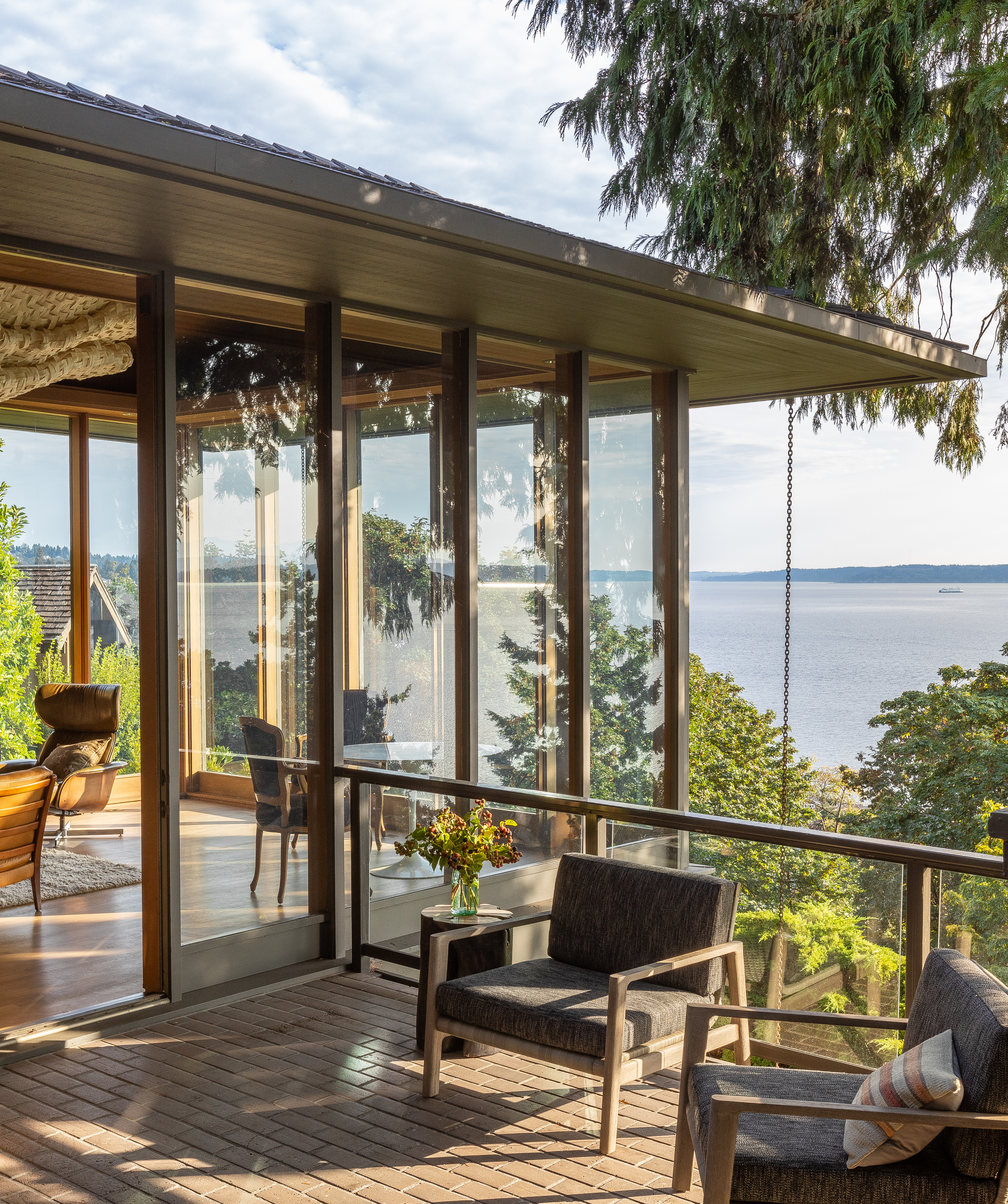 The living space, with its floor-to-ceiling windows and patio access, feels like a glass box nestled in the trees. Inside or out, the panoramic view is breathtaking.