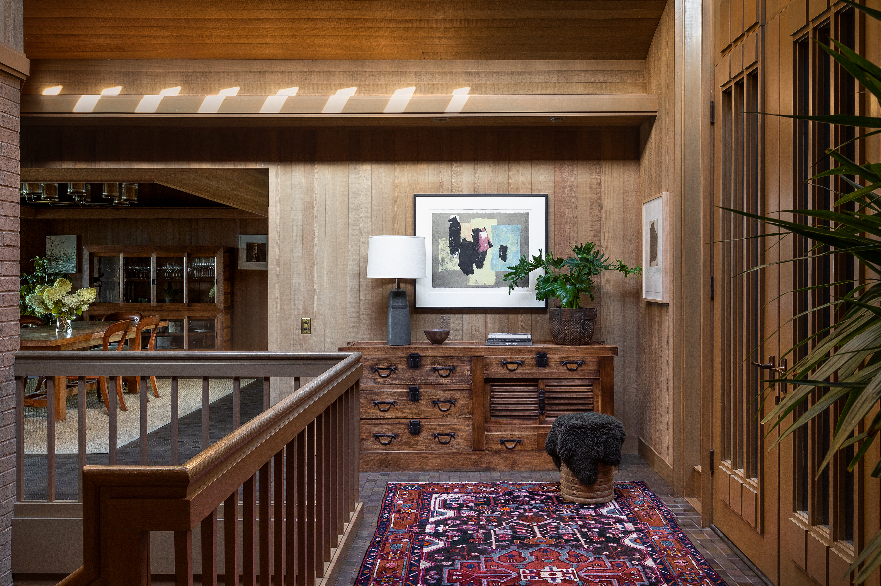 As you enter, cedar-clad walls embrace you, complemented by playful lighting from the skylight, casting warm, inviting shadows against the wood paneling.