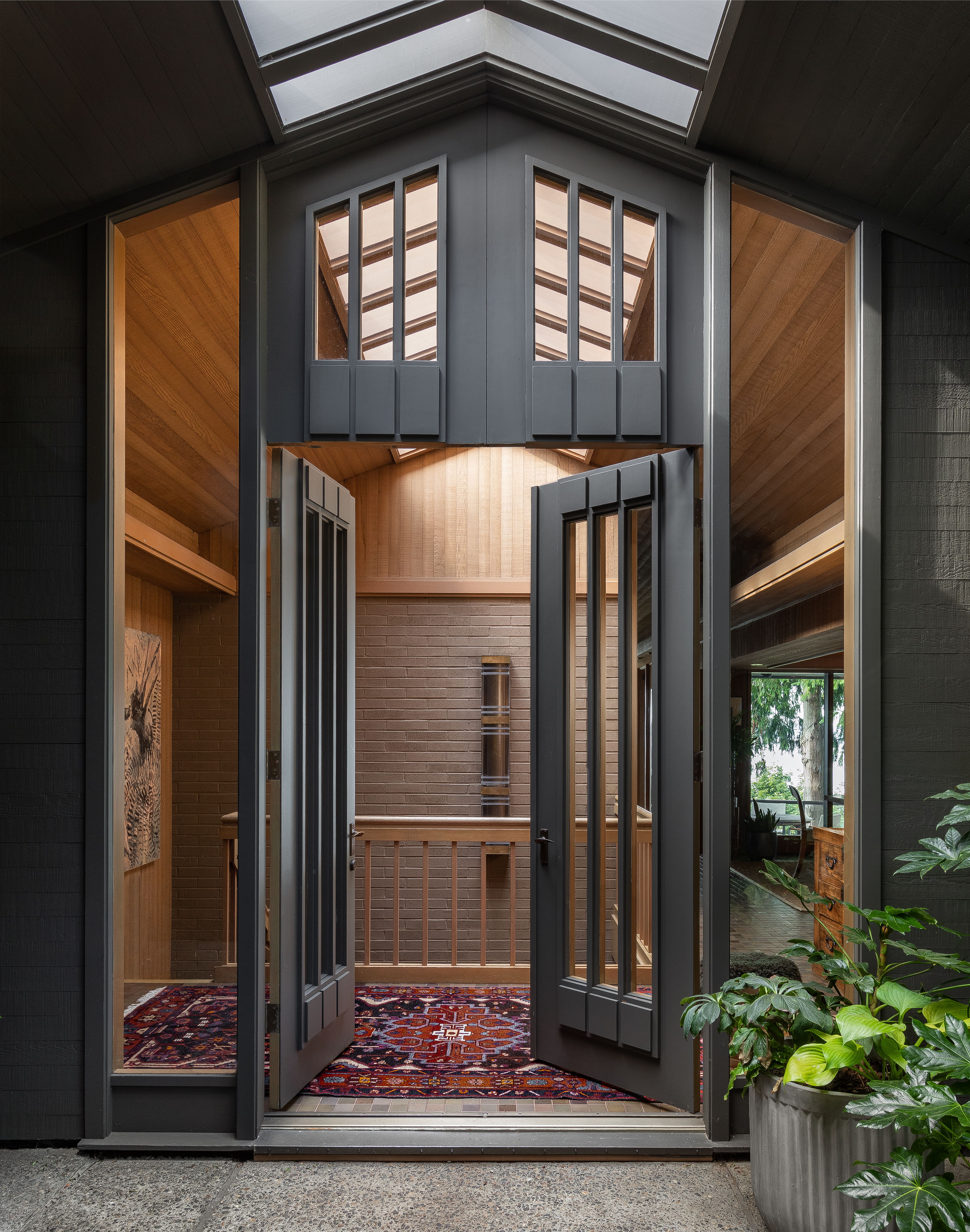 The front entry makes a bold statement with its tall, impressive design, featuring expansive glass windows that flood the space with natural light.