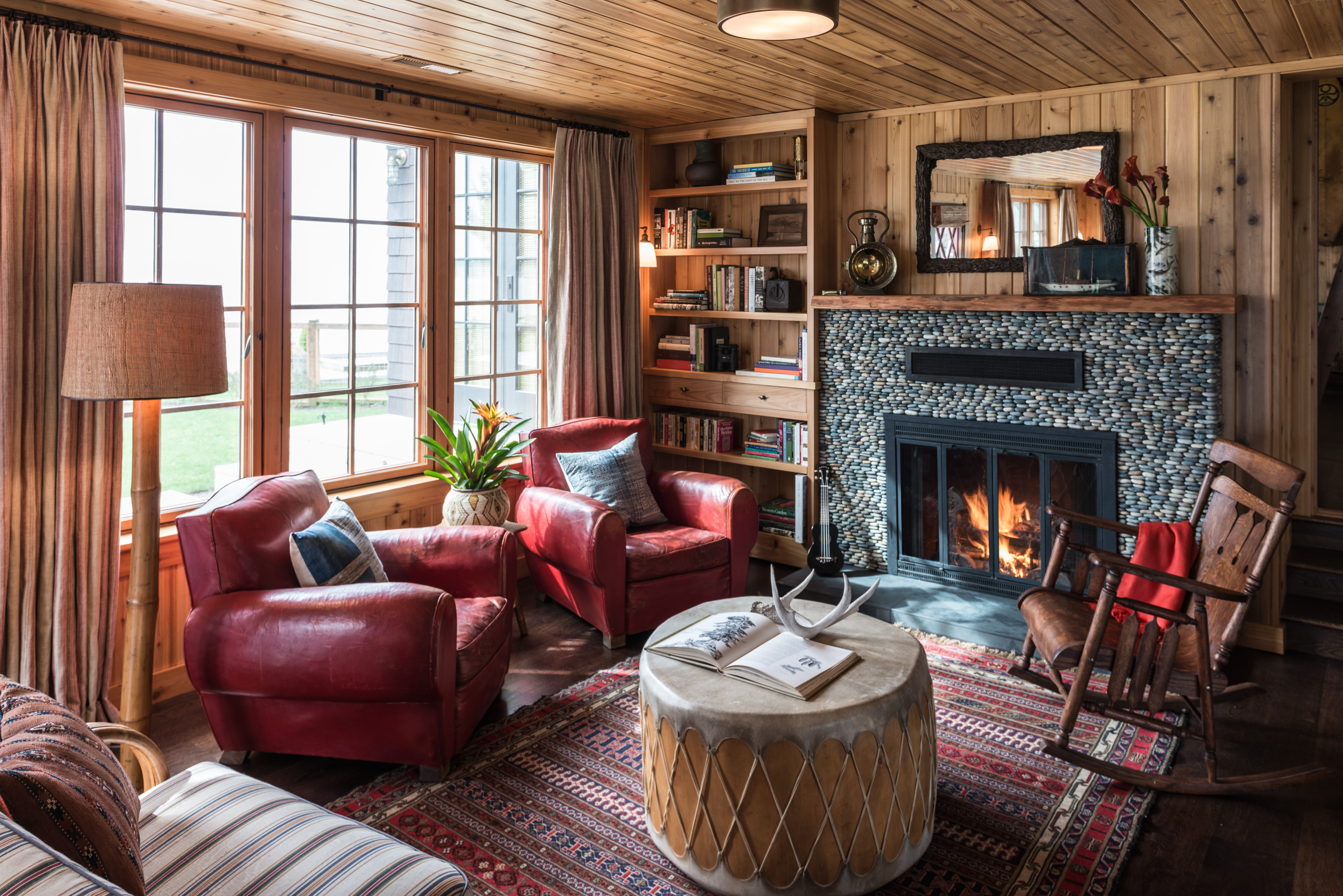 The river rock fireplace in the great room exudes a rustic charm, anchoring the space with its natural beauty and providing a cozy focal point for gatherings.