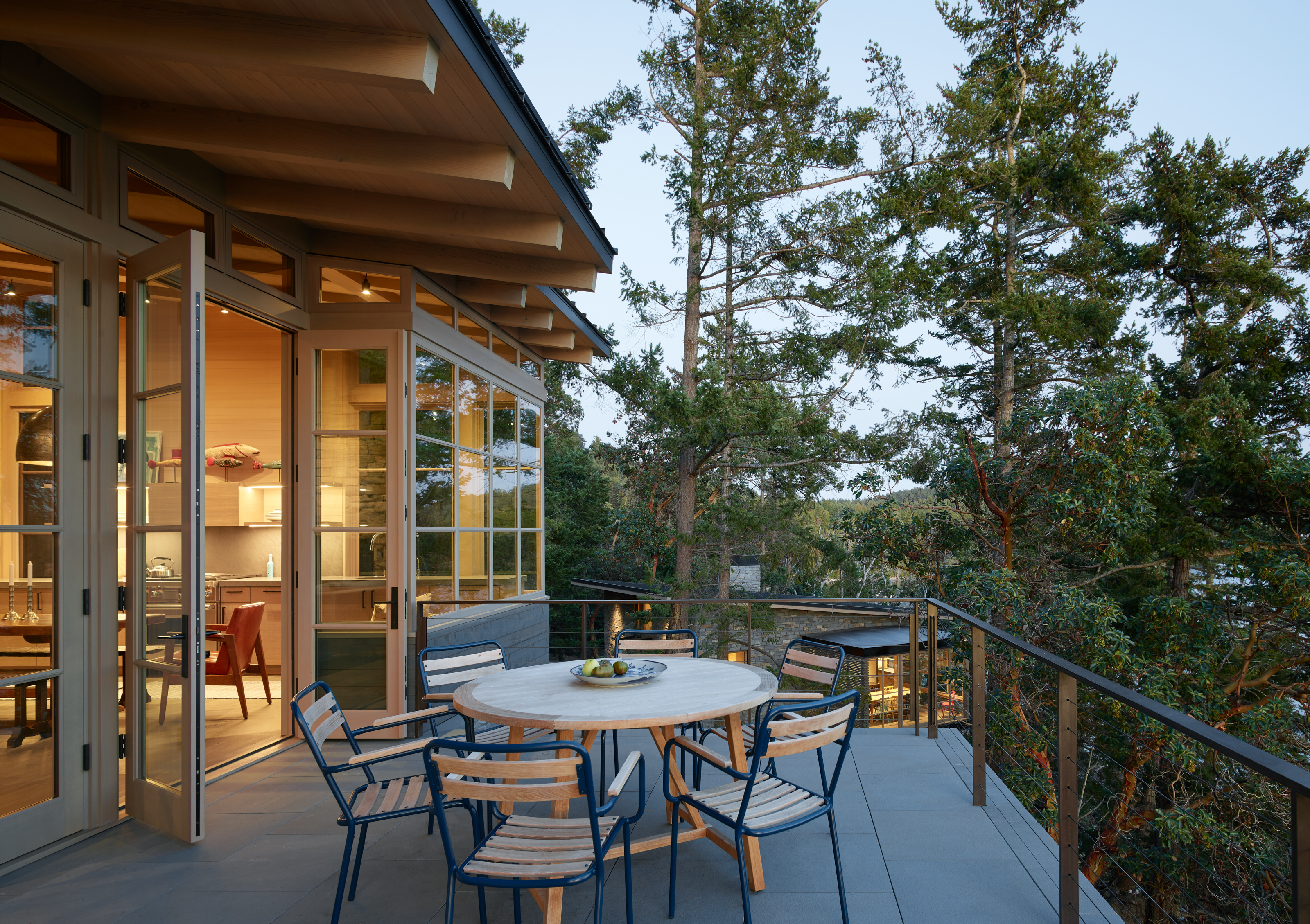 A spacious balcony outside the kitchen, perfect for outdoor dining, with a view of the guest house in the background, creating a serene outdoor living space.