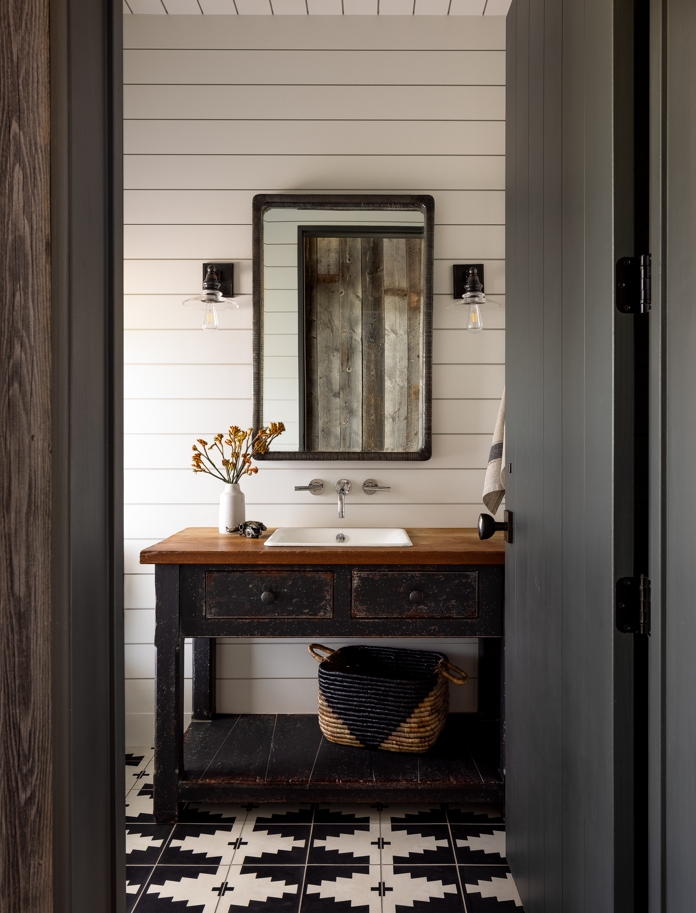 Vintage console table converted to a bathroom vanity paired with horizontal paneling.