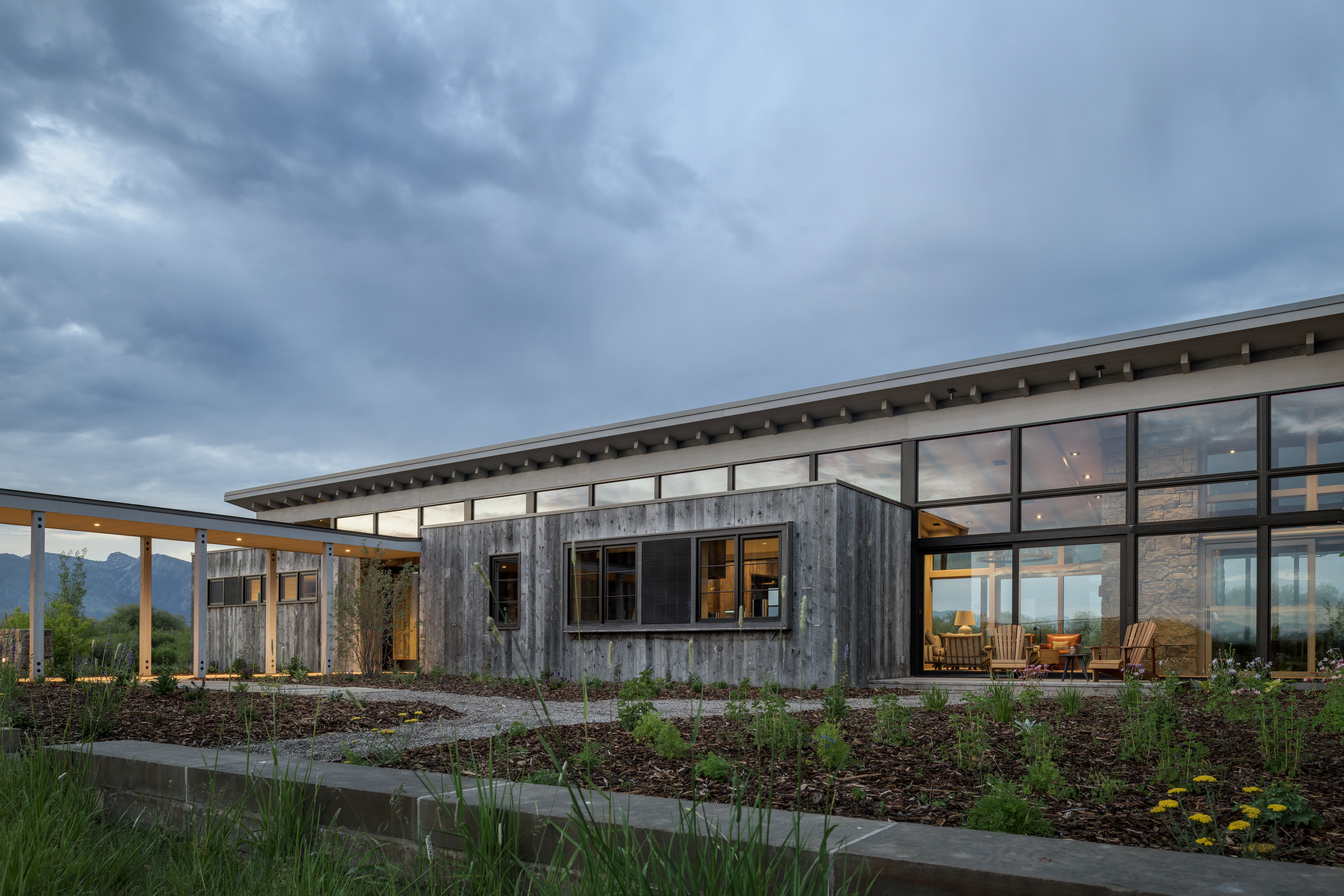 Alternate view of Wyoming Retreat's entry, highlighting the expansive windows and an outdoor seating area for enjoying pleasant weather