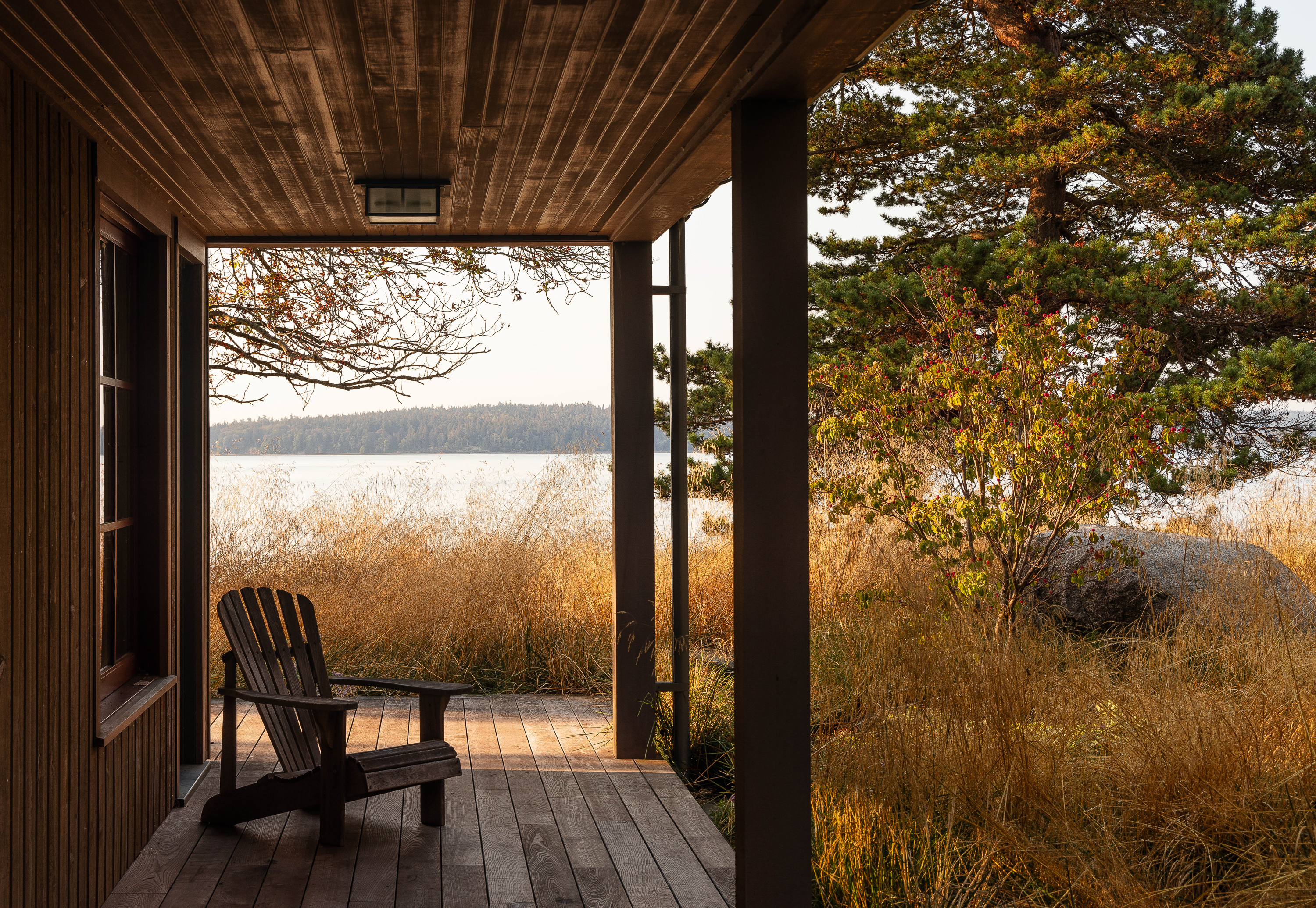 View from the studio building porch, featuring a solitary Adirondack chair beneath the covered area, offering a serene spot to enjoy the picturesque view of Puget Sound