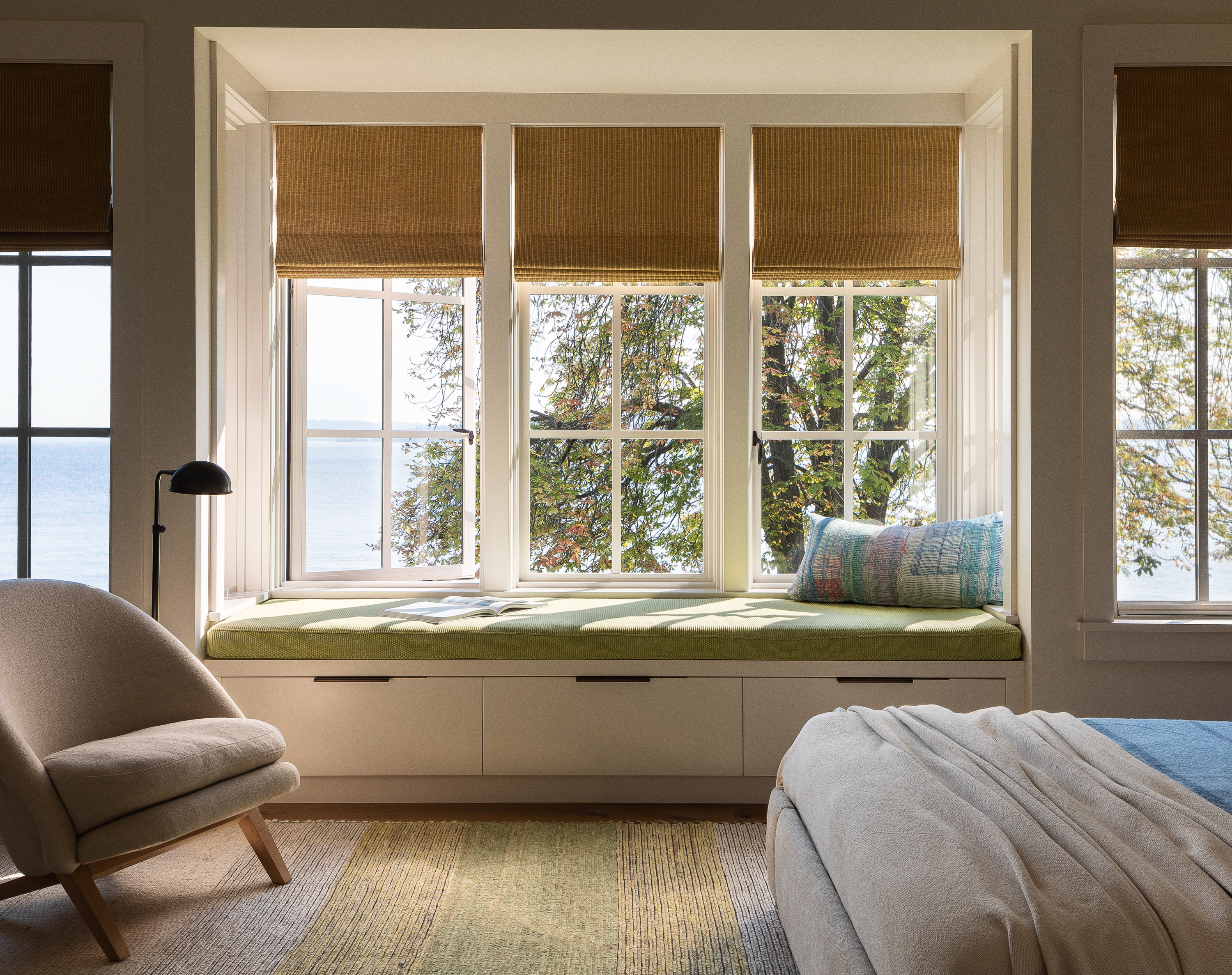 The guest room, located upstairs, is bright and airy with pops of green and blue accents. It features a window seat offering awesome views, adding to its inviting charm.