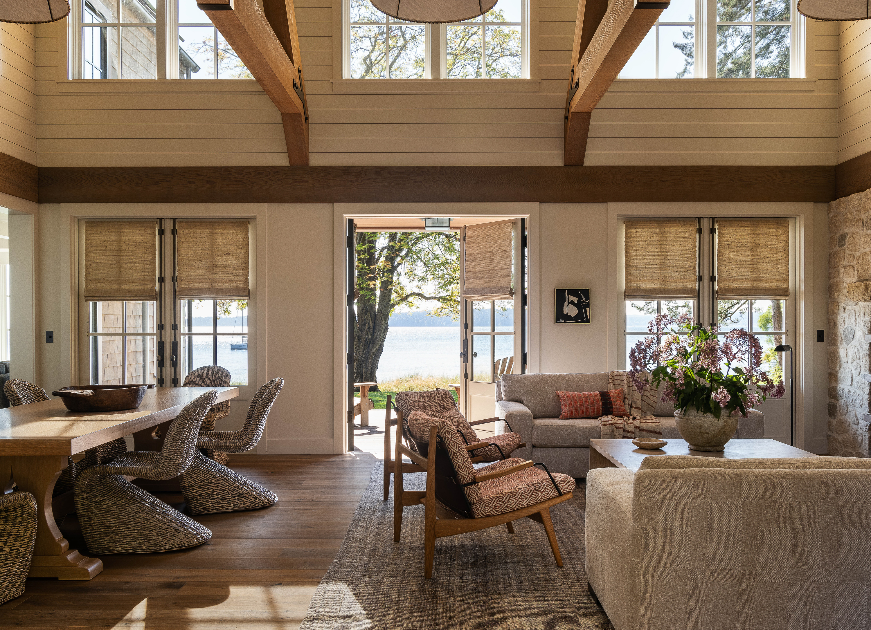 A view through the open concept living and dining area, revealing three sets of double doors that open to the waterfront, seamlessly integrating the indoor and outdoor spaces.