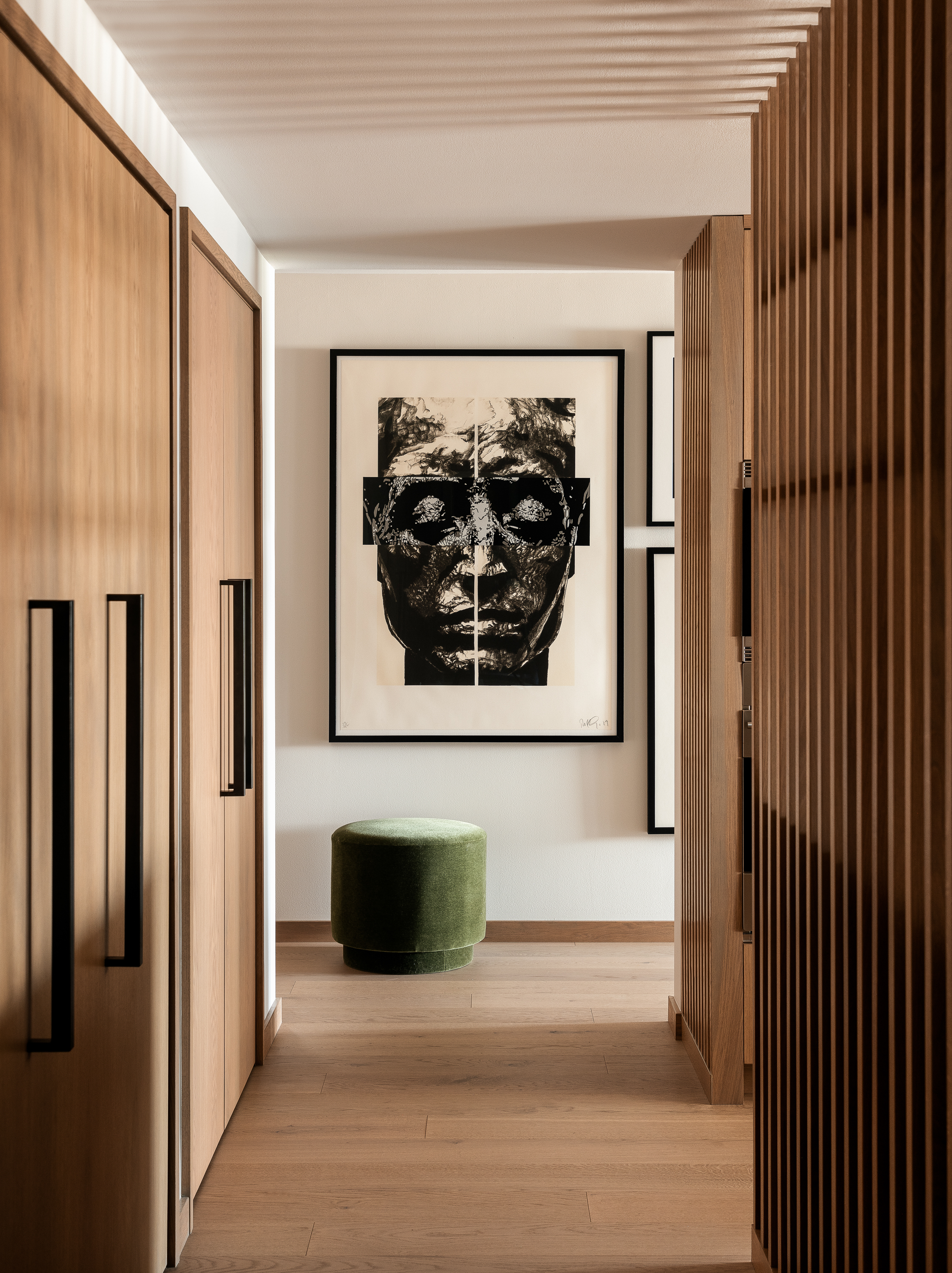 A Robert Longo Painting at the end of a white oak finish hallway.